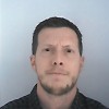 Man with short hair and beard in passport photo.