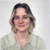 Smiling person with glasses and short hair